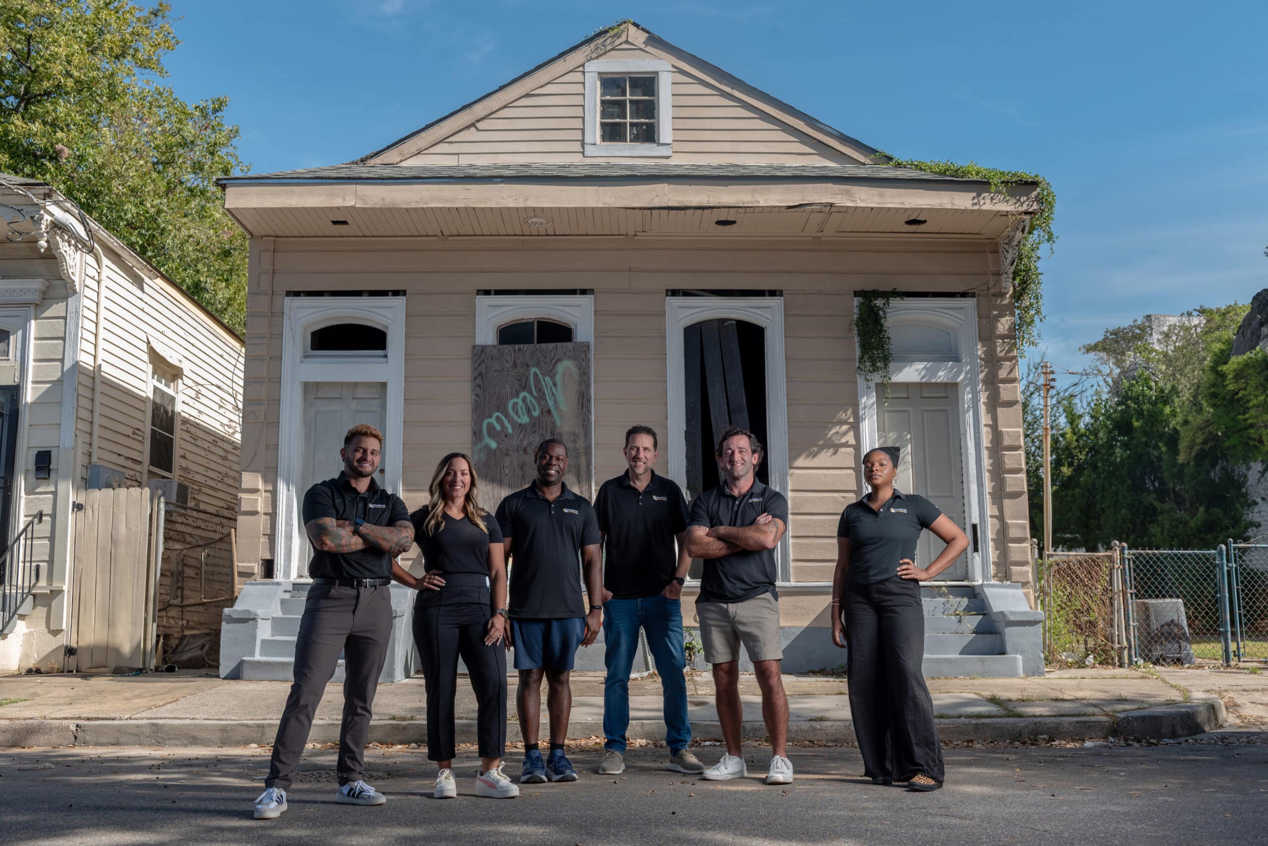 Home Buyer Louisiana acquisition team standing in front of a purchased property after their 50th closing in 2025 in New Orleans area.